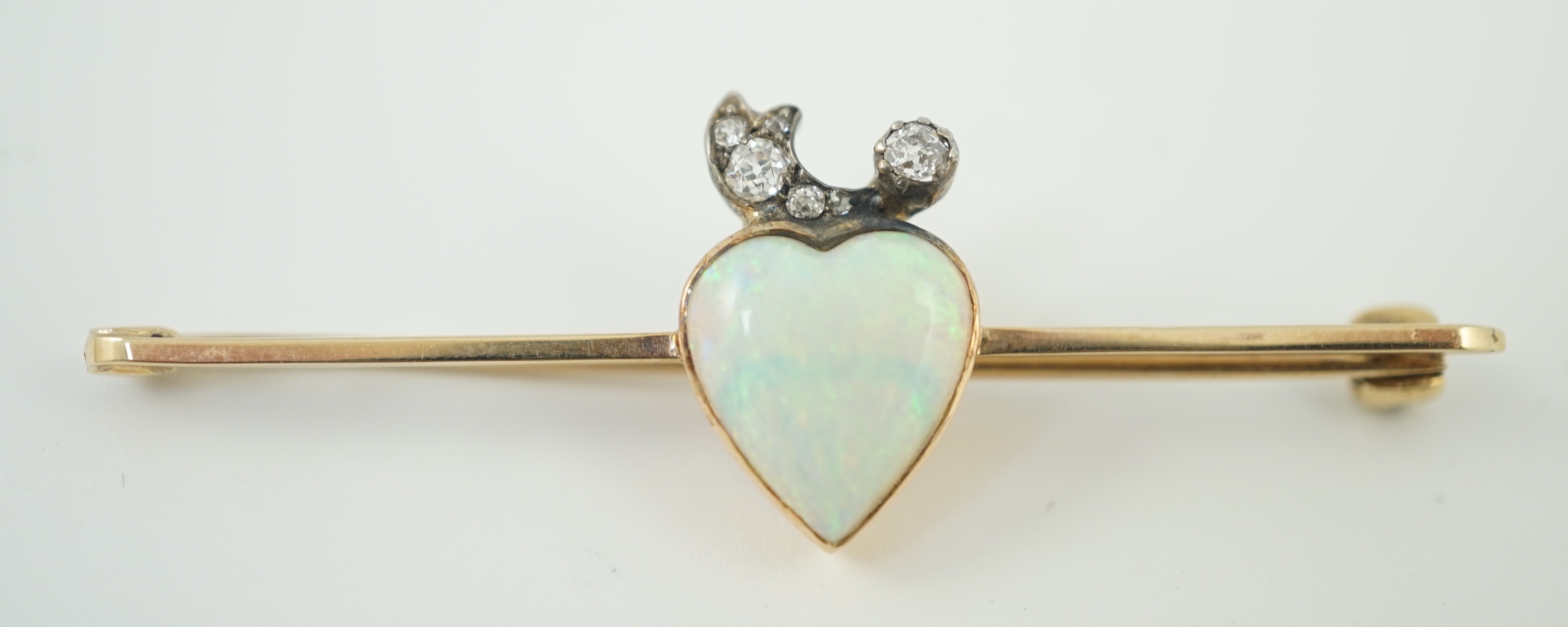 An early 20th century gold, heart shaped white opal and six stone diamond set bar brooch